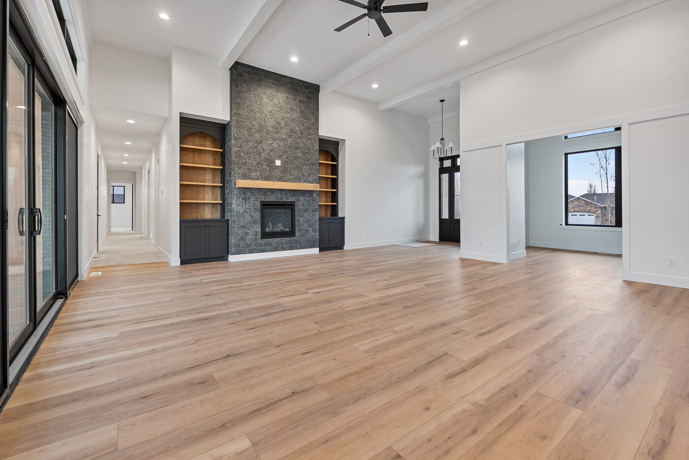 Great room alternate angle showing fireplace wall and built-in shelving
